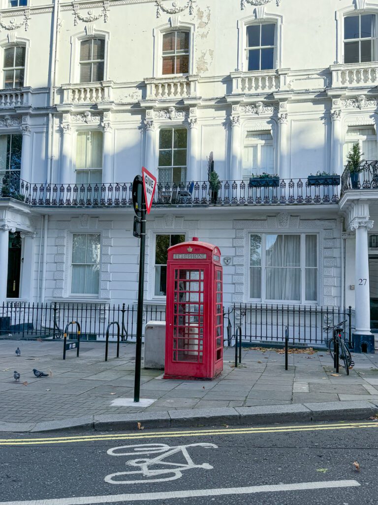 Rote britische Telefonzelle vor viktorianischen Wohnhäusern im Bayswater Viertel, London